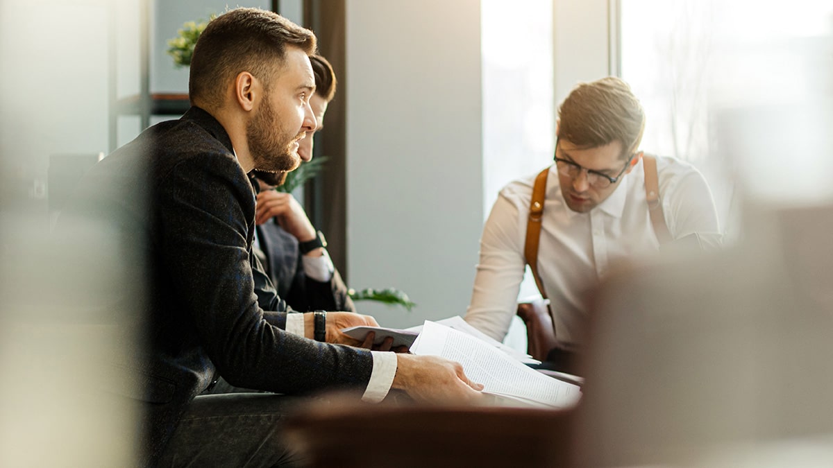 Two business professionals reviewing documents during a workplace meeting.