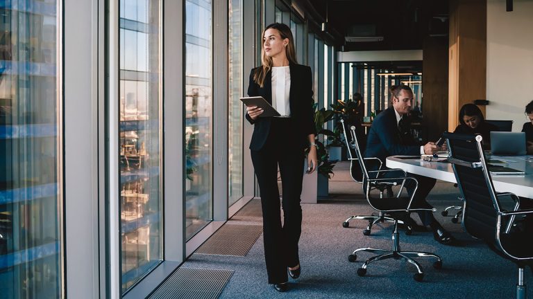 Businesswoman strolling through corporate meeting room