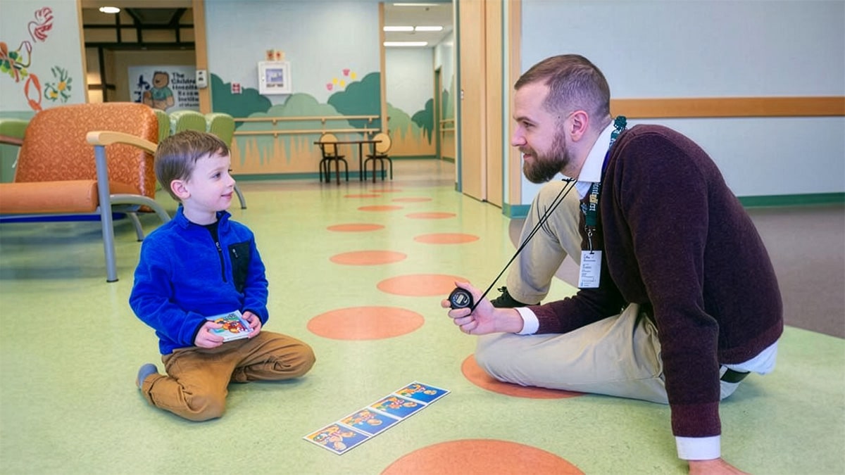 Health psychologist doing activity with boy in clinic