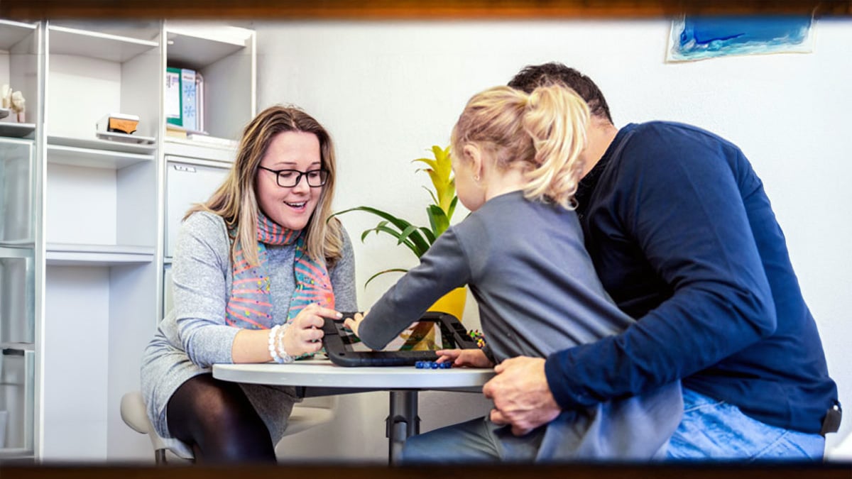 Neuropsychologist with young patient and father