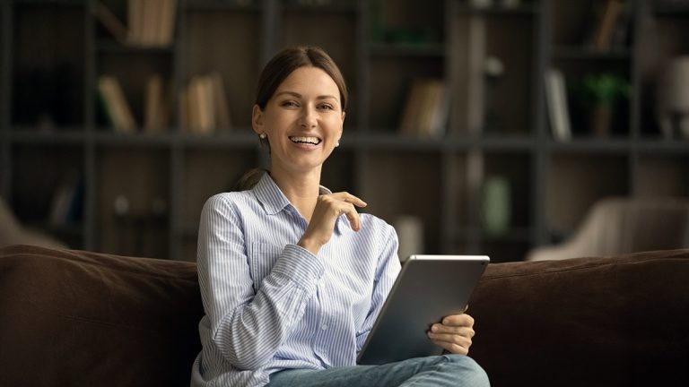Working professional using a tablet while studying for an MBA outside work hours.