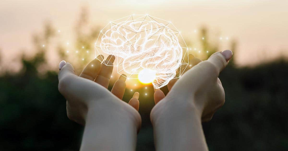 Woman holding symbol lit-up brain to symbolise psychology
