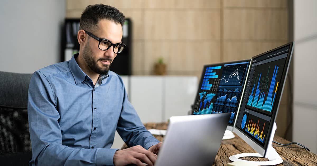 Analyst displaying charts on multiple screens