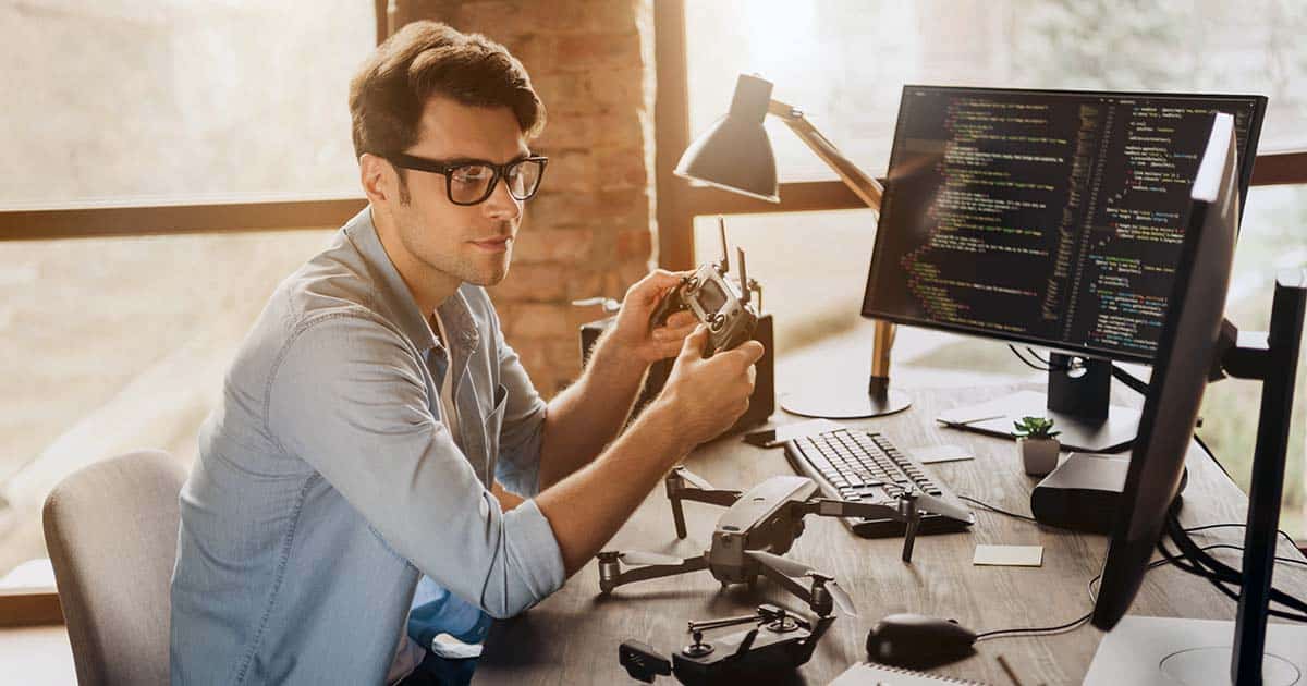 Technology professional at computer testing a drone controller