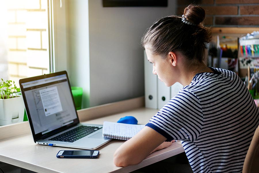 Young woman studying with laptop in home office