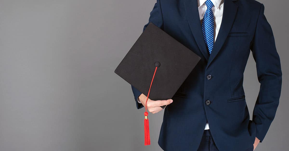 Businessman holding graduation cap