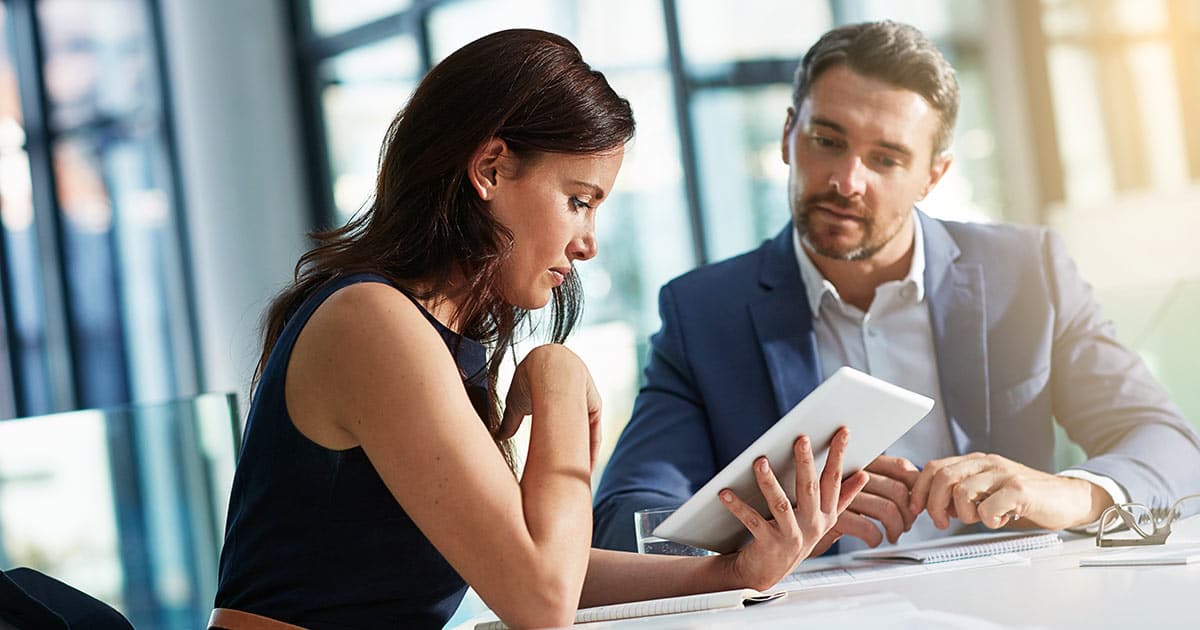 Business meeting with two professionals using computer tablet