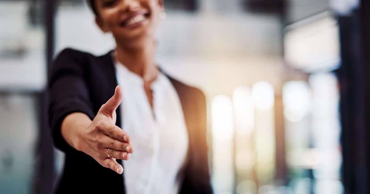 Smiling woman reaching out to shake hands