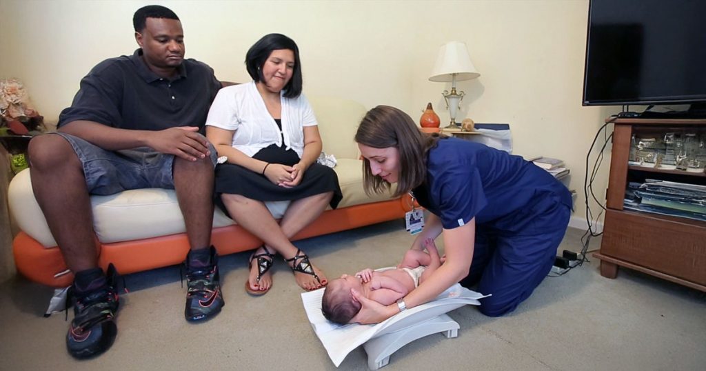 Child and family nurse weighing baby