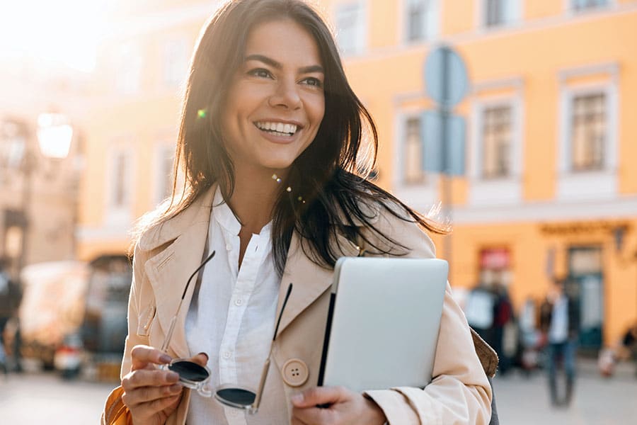 Smiling female professional holding computer tablet outside