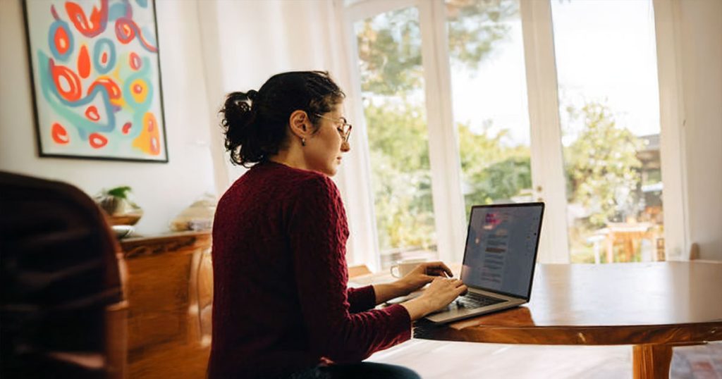 Creative woman at home using laptop