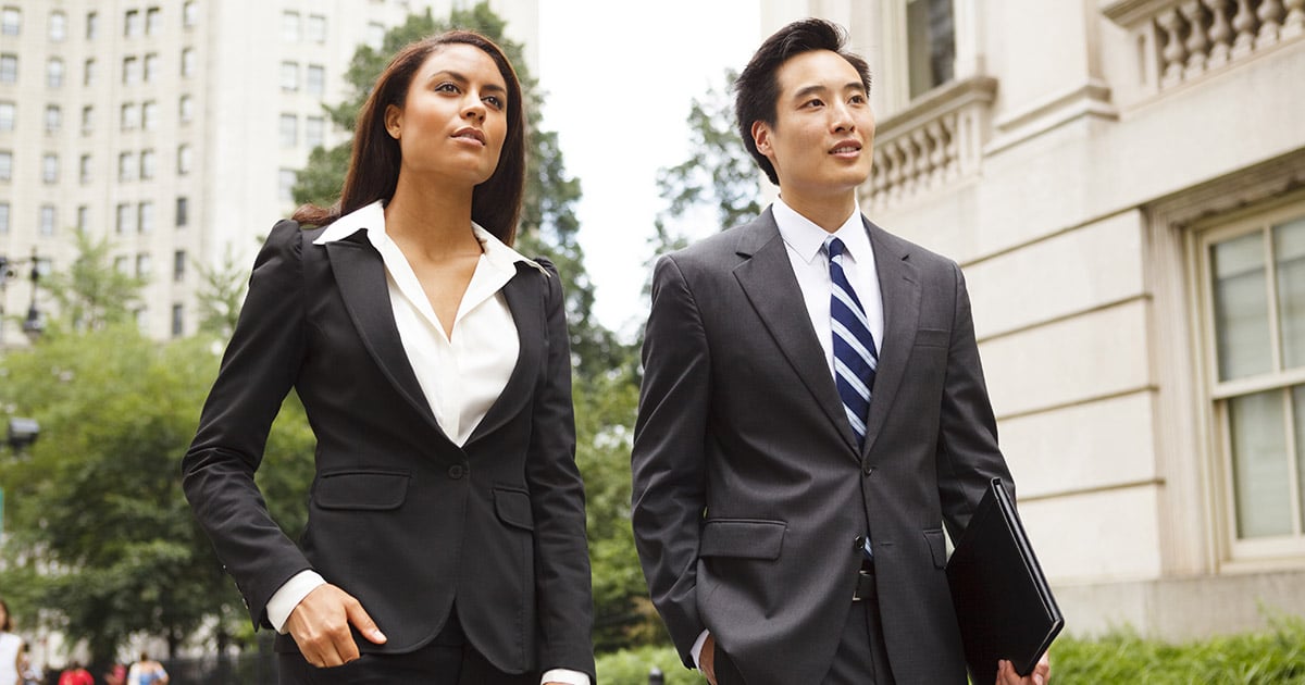 Young smartly dressed professionals walking along city street