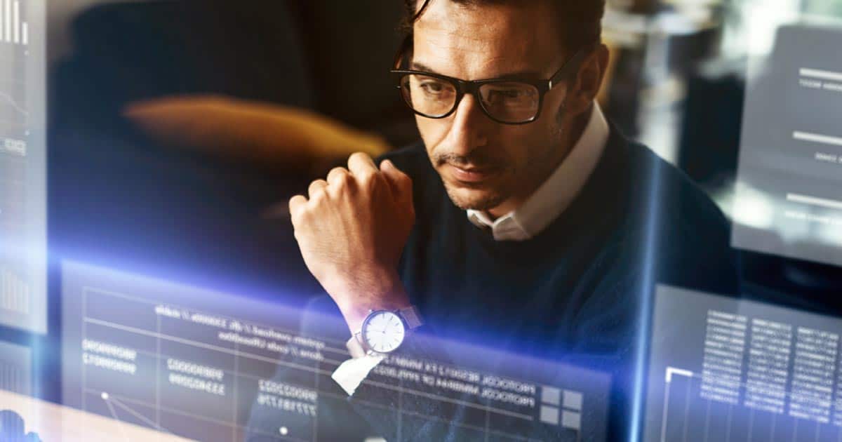 Professional man inspecting charts and codes on computer