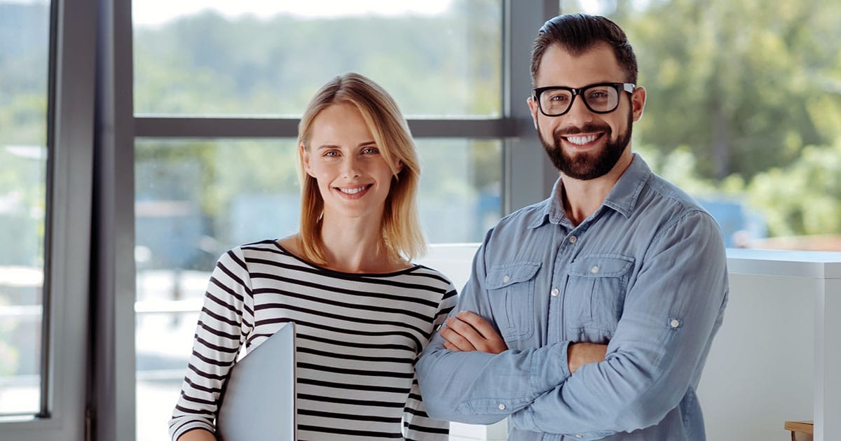Professional man and woman smiling in office