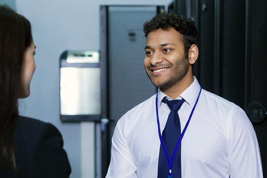 Professional man and woman shaking hands in computer hardware room