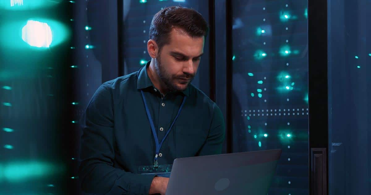 Tech professional working on laptop in computer lab