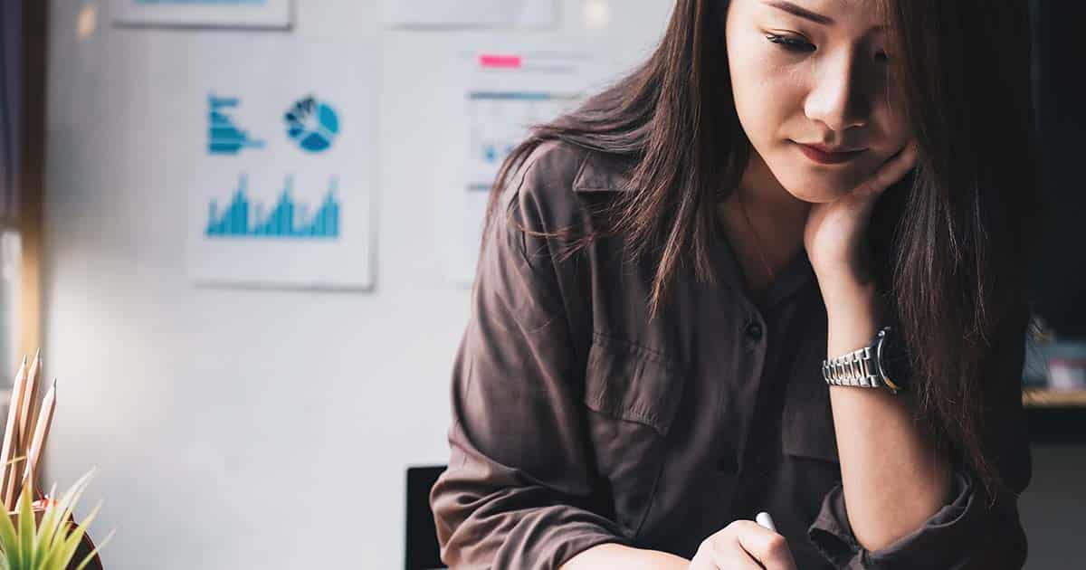 Woman writing with charts in background