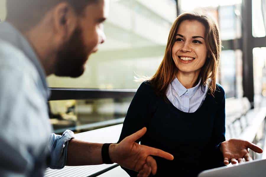 Man and woman smiling to one another at work