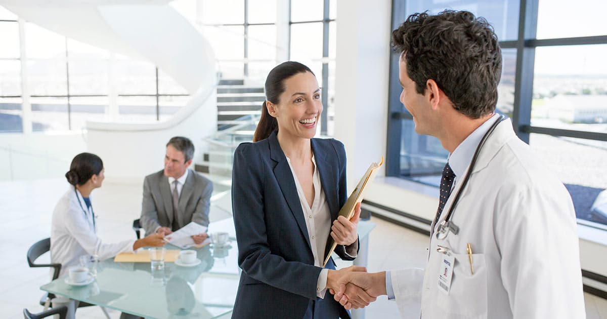 Doctor and businesswoman shaking hands