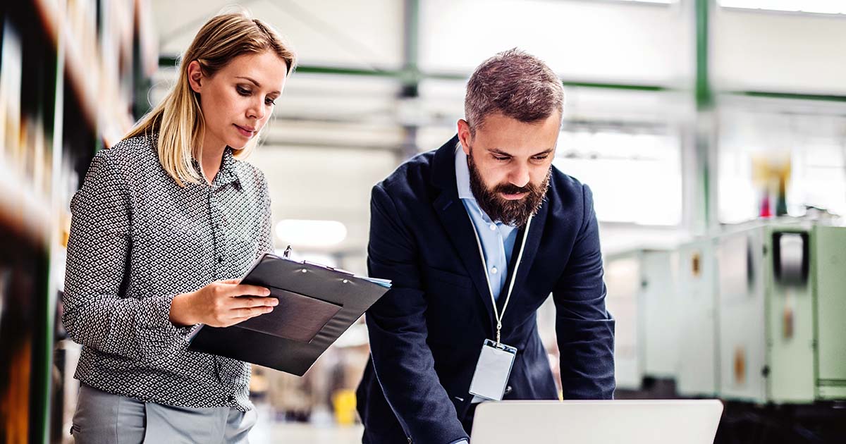 Two professionals looking over data on a computer