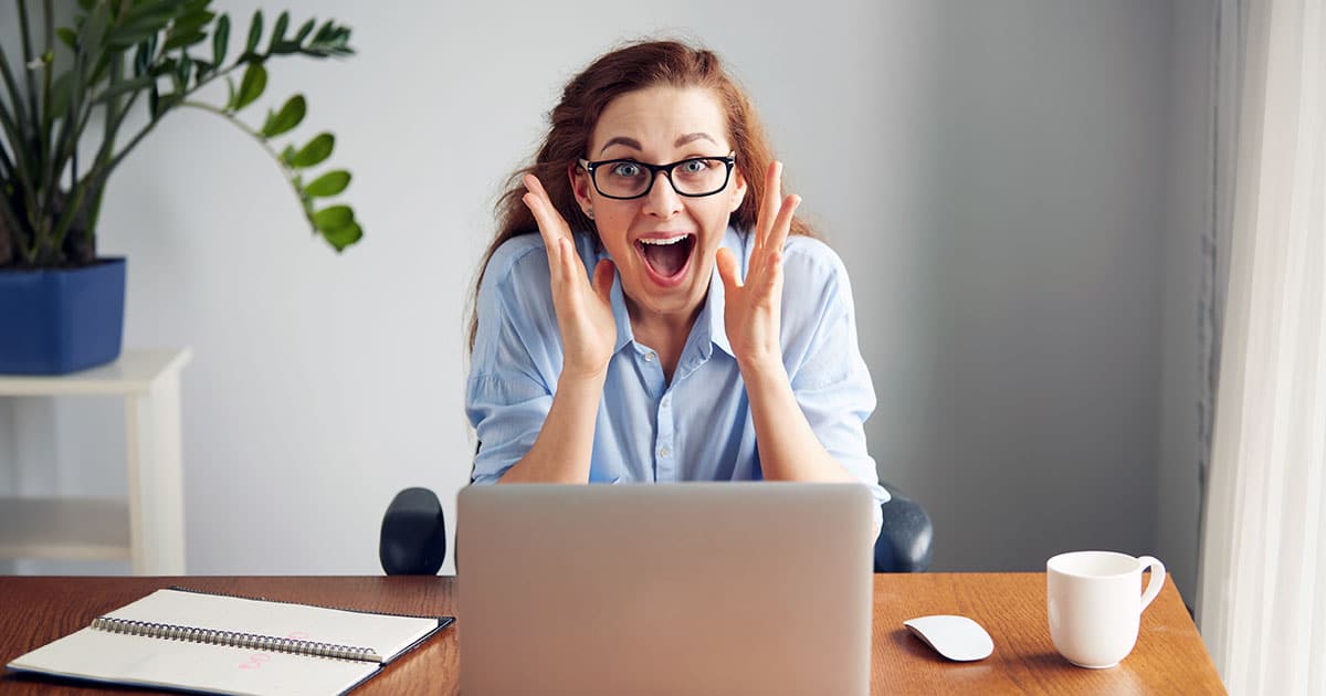 Excited young woman at computer