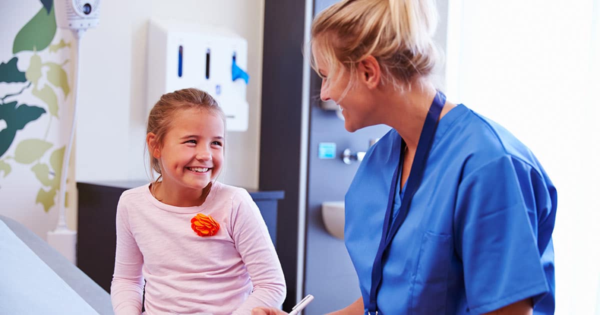 Female medical staff member with girl patient