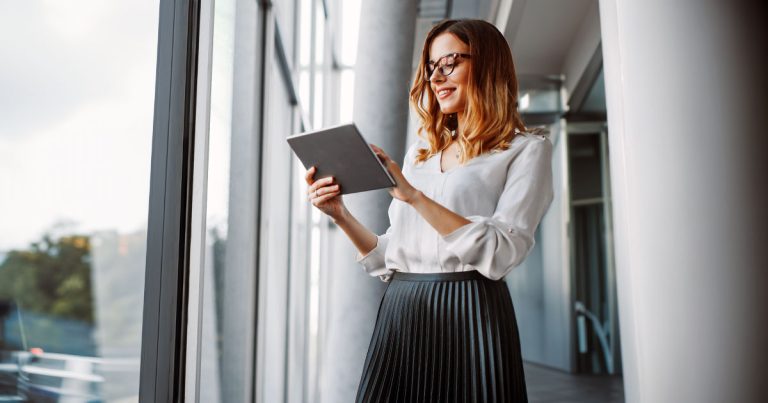 Female professional using tablet device while standing