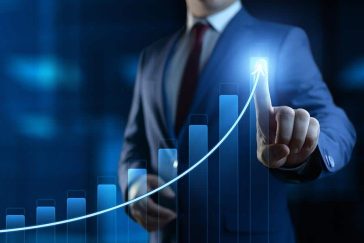 Professional man tracing out chart with upward trendline