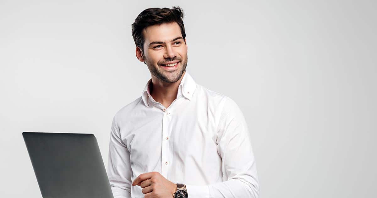Smiling professional man using laptop standing up