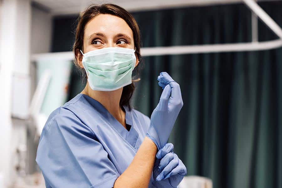 Female nurse or doctor putting on surgical gloves