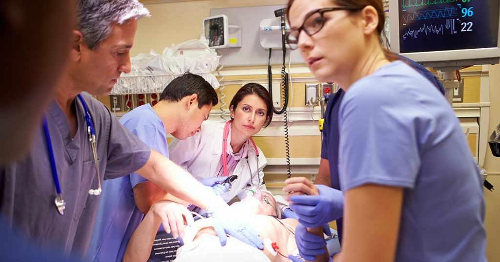 Nurses and medical professionals working on a patient in an emergency ward