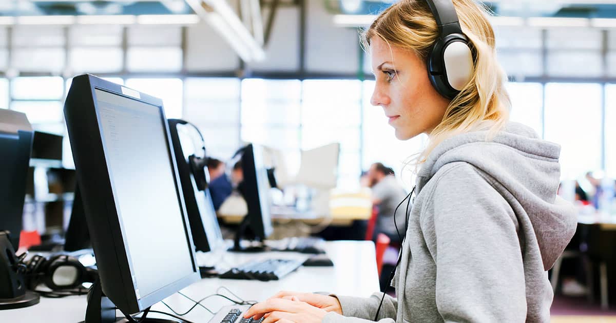 Woman in computer lab with headphones on