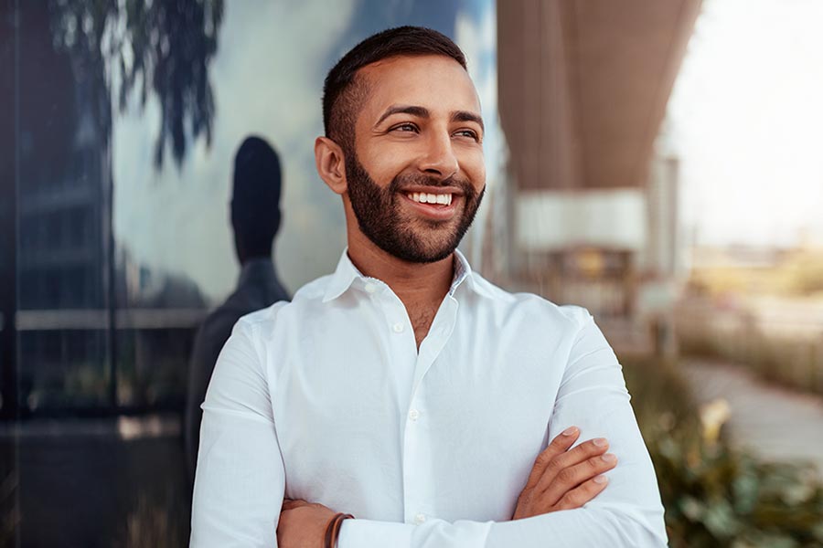Man smiling outside commercial building