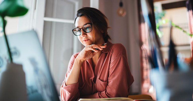 Young woman wearing glasses using computer