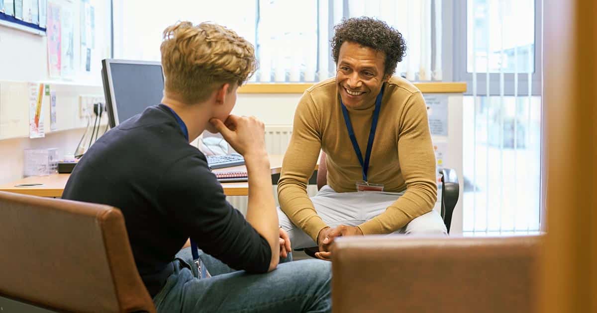 Friendly conversation in office between youth worker and client