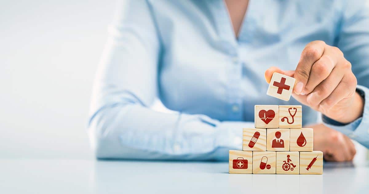 Woman stacking blocks with health symbols