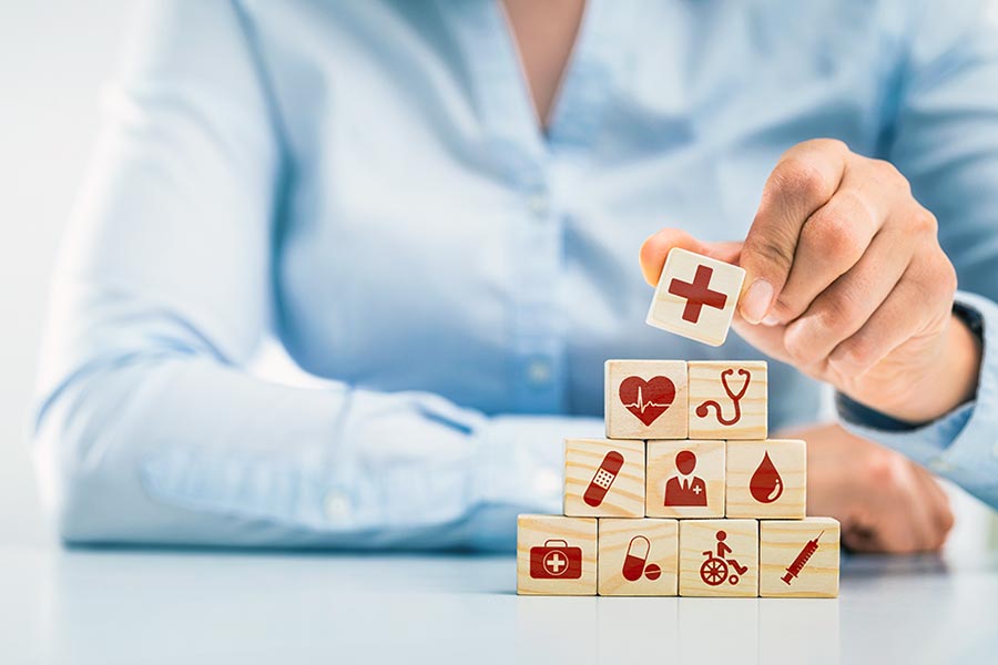 Woman stacking blocks showing health symbols
