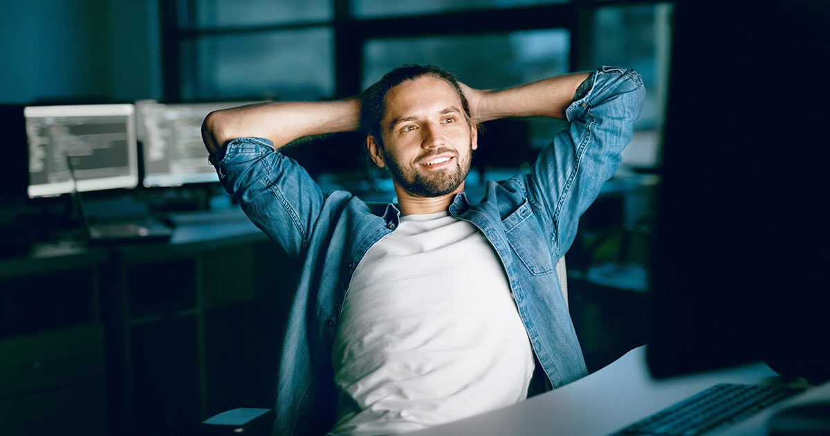 Relaxed young man surrounded by computers