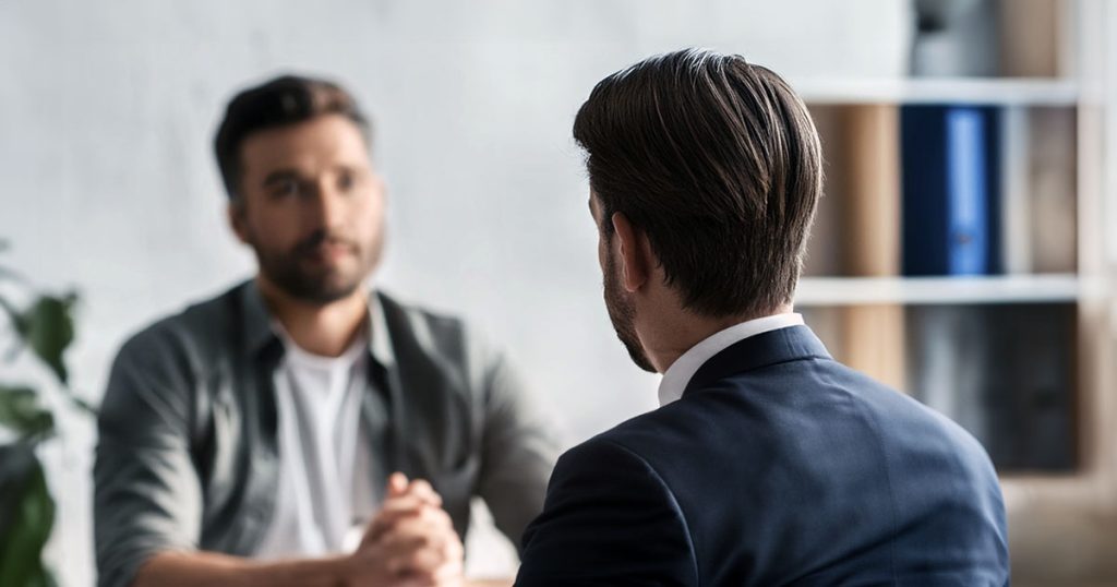 Intense meeting across table between two men