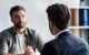 Intense meeting across table between two men