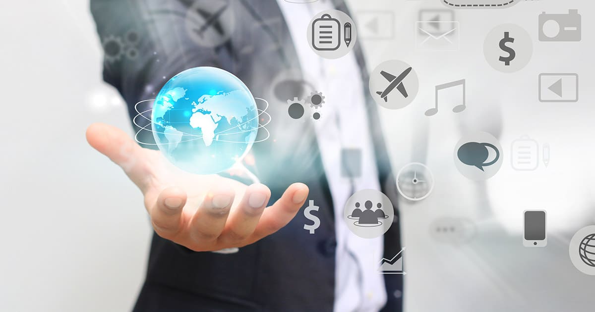 Businessman holding spinning globe, surrounded by business and media symbols