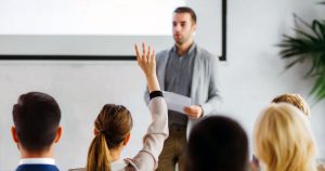 Man giving work presentation with questions