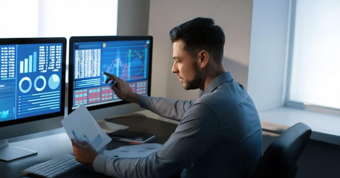 Man tracing charts on computer screen