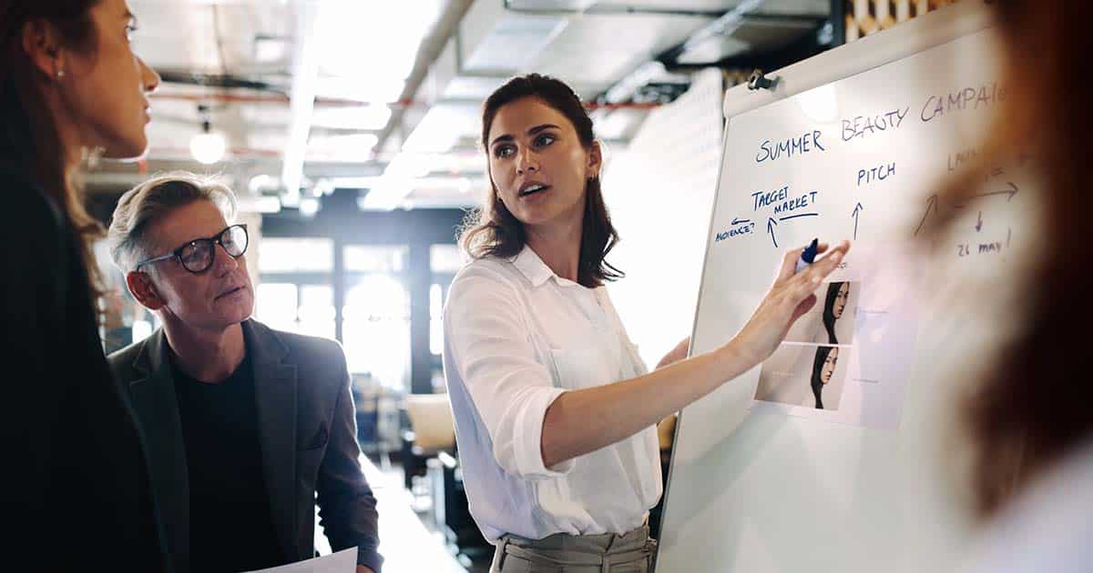 Female marketer outlining campaign with help of whiteboard