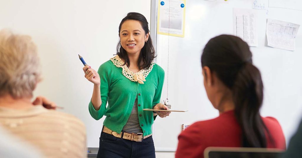 Woman in front of whiteboard leading a presentation