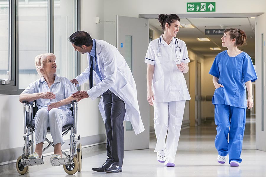 Hospital staff and patient in wheelchair in corridor