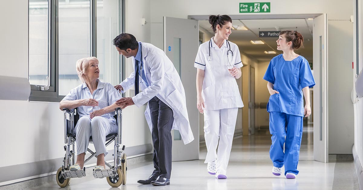 Hospital setting with staff and patient in wheelchair