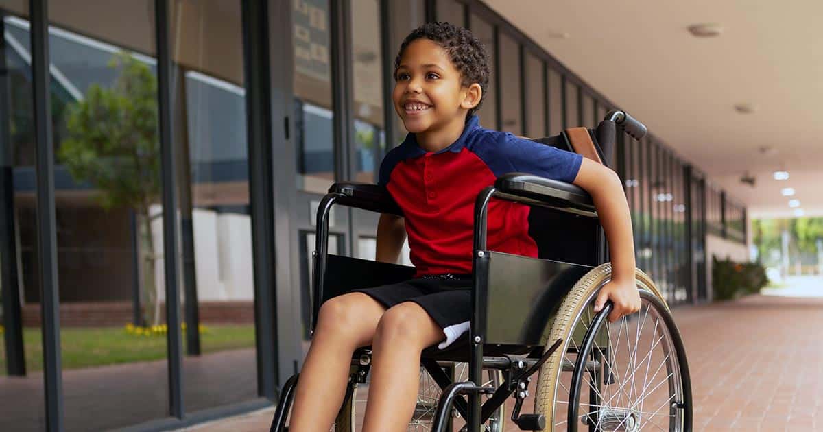 Boy in wheelchair propelling himself forward