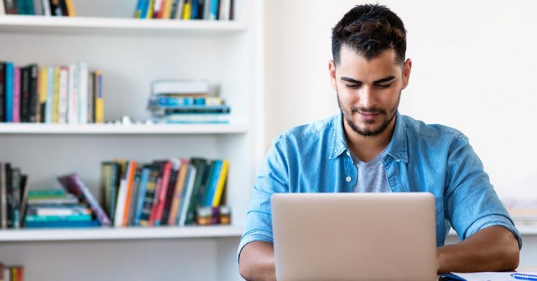 Young man using laptop in home office