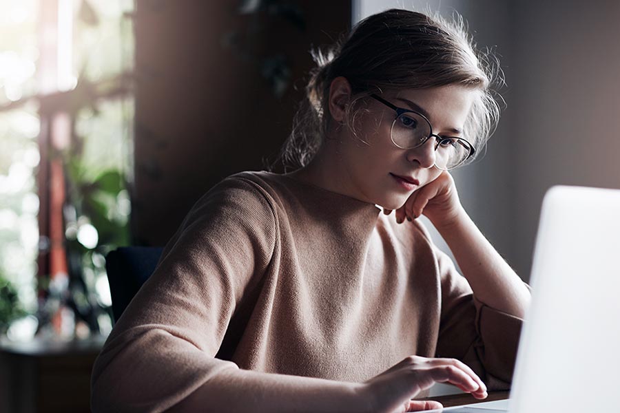 Woman wearing glasses using laptop